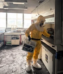 A specialist in protective equipment cleaning a laboratory