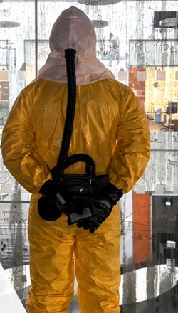A specialist in a hazmat suit with a powered respirator